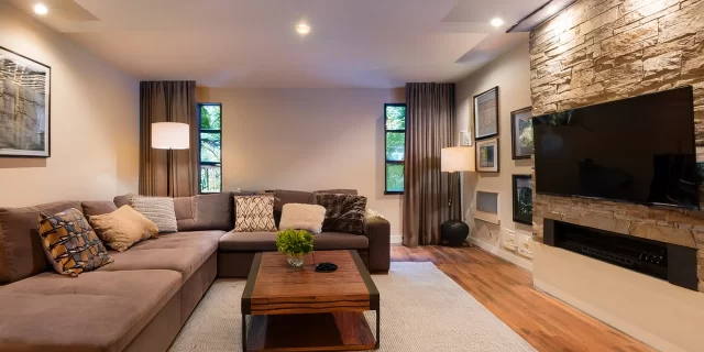 Firefly A beautifully remodeled basement transformed into a cozy living space with stylish lighting,